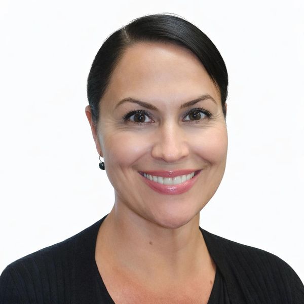 Professional woman with dark hair smiling against a white background.