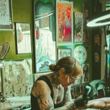 Tattoo artist working in a vibrant studio filled with art.