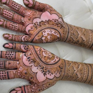 Intricate mehndi designs featuring royal figures on both hands.