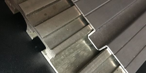 Close-up of interlocking metal panels with a brushed finish.