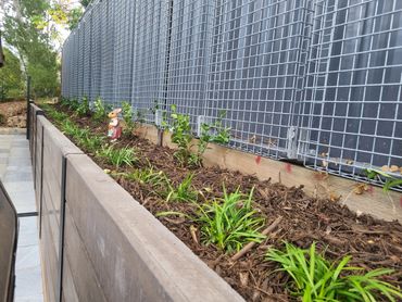 Colorbond trellis panels above concrete sleepers retaining wall