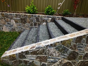 Concrete sleepers used to form steps between Bluestone retaining wall