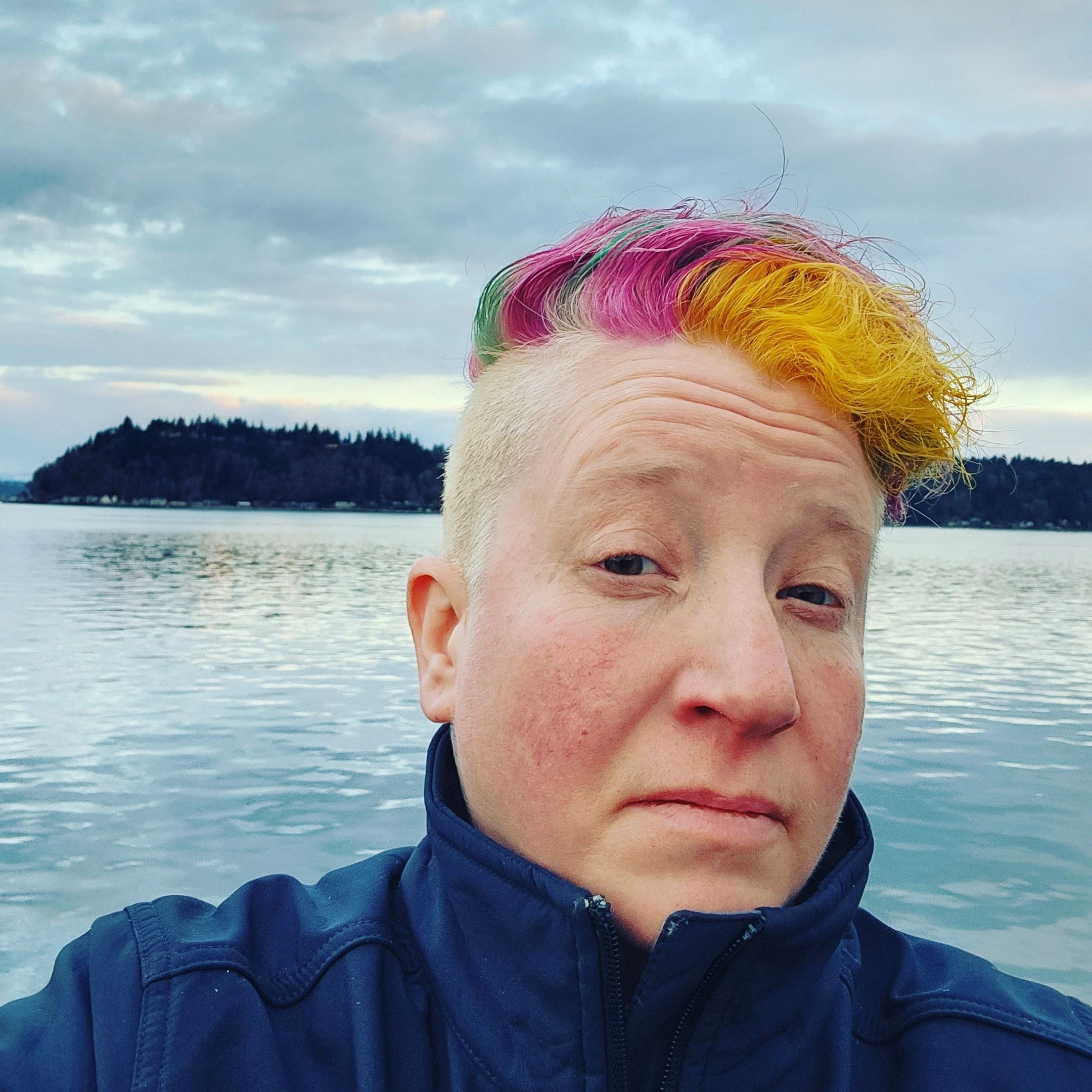 Person with colorful hair by the water.