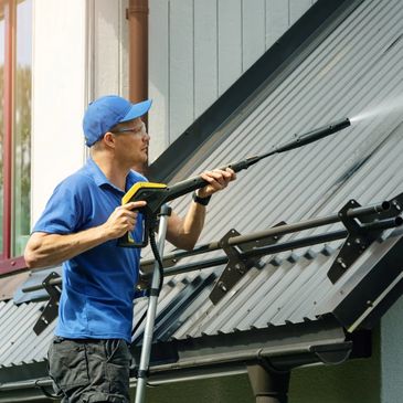Roof washing, a man soft washing the roof