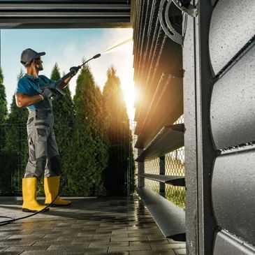 A man soft washing a house exterior 