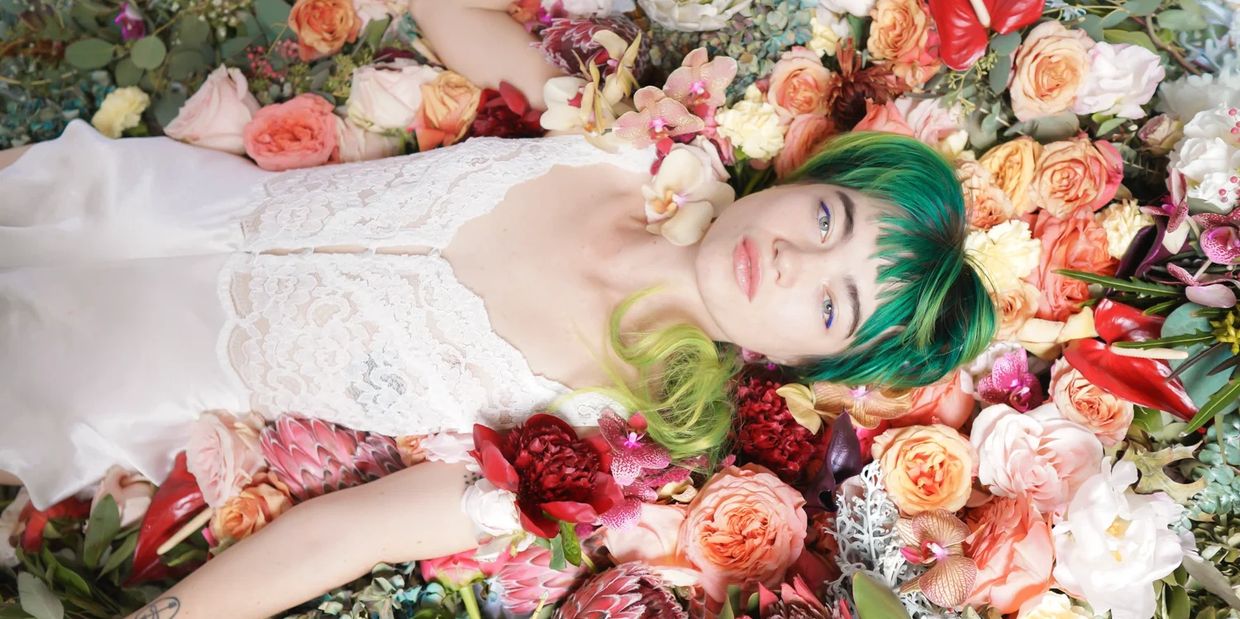 a woman laying on a bed of flowers