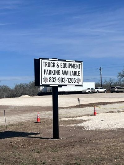 Sign for truck and equipment parking with phone number.