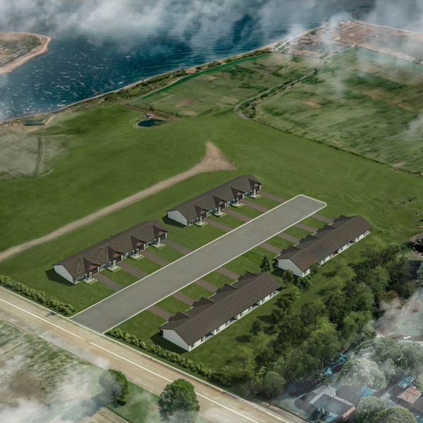 3D aerial rendering of waterfront townhome development surrounded by greenery.
