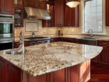 Elegant kitchen with a large granite island and dark wood cabinets.