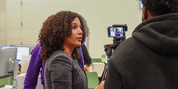 Woman speaking on camera during an indoor interview setup.