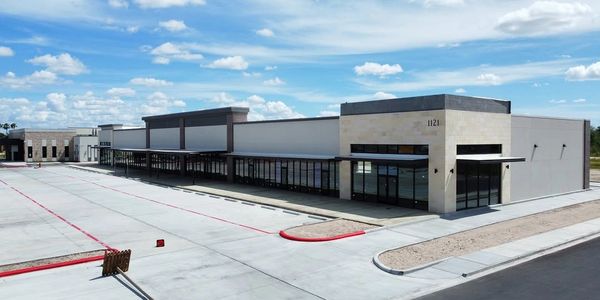 Empty modern commercial building under a blue sky.