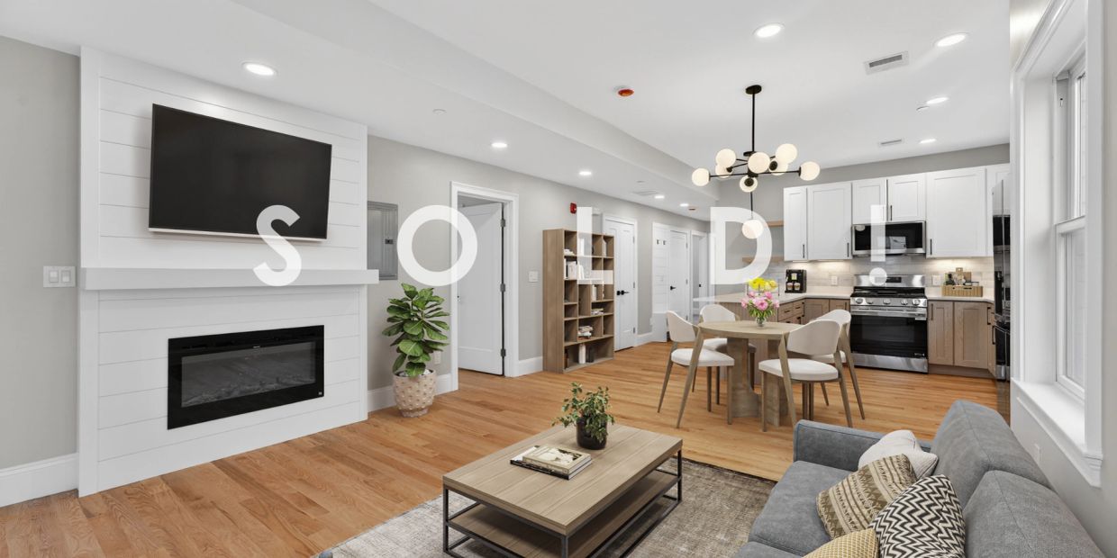 Modern open-concept living room and kitchen with hardwood floors and stylish furniture.