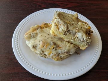 Biscuits and gravy on a white plate.