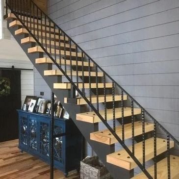 Modern wooden staircase with black metal railing in a cozy home.