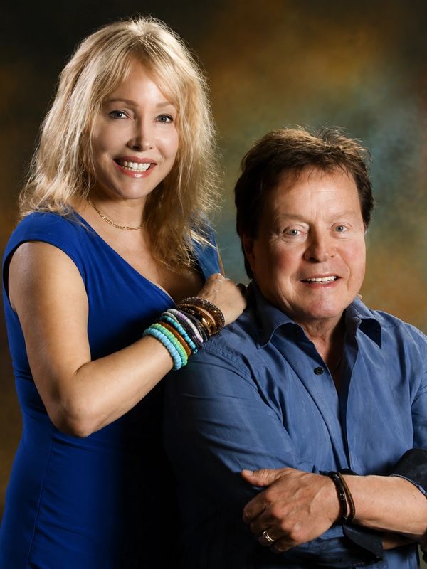 Smiling couple posing together in coordinated blue outfits.