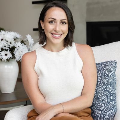 Smiling woman sitting on a chair indoors.