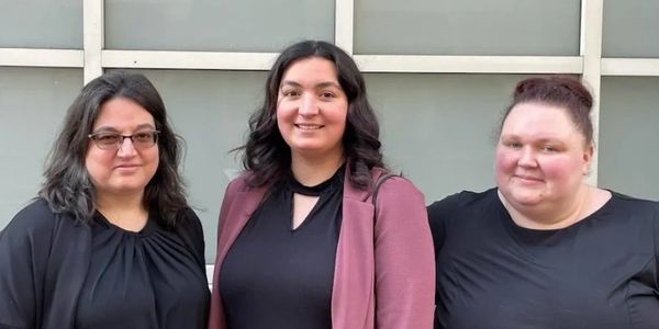 Kris Brunetto, Marie Mellick, and Christine Mellick stand outside of a building