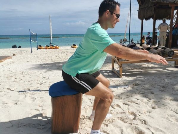Osteopath doing proper squat technique with a stool to maintain form