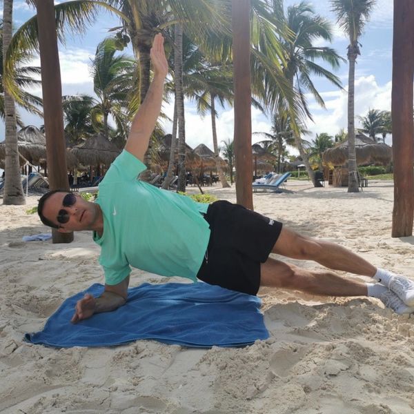 Wimbledon Osteopath correctly doing a side plank on the beach to strengthen oblique muscles