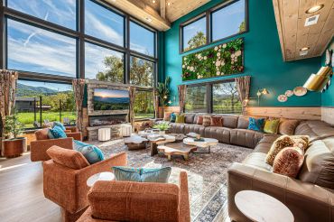 Spacious living room with large windows and cozy seating.