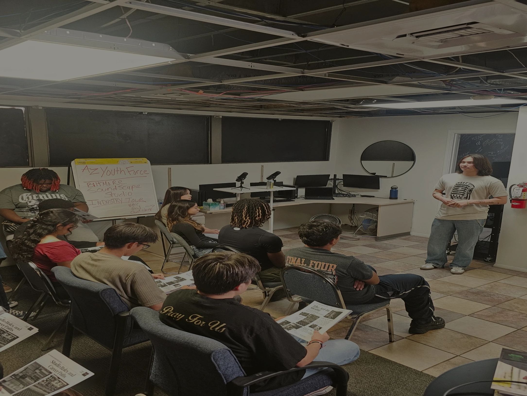 A group of young people attending a studio industry tour presentation.