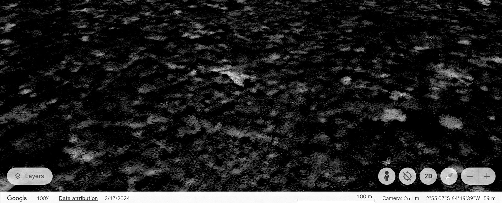 A dark, rocky terrain with scattered lighter patches, viewed from above.