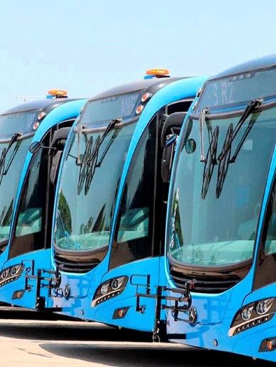 Cuatro autobuses azules alineados.