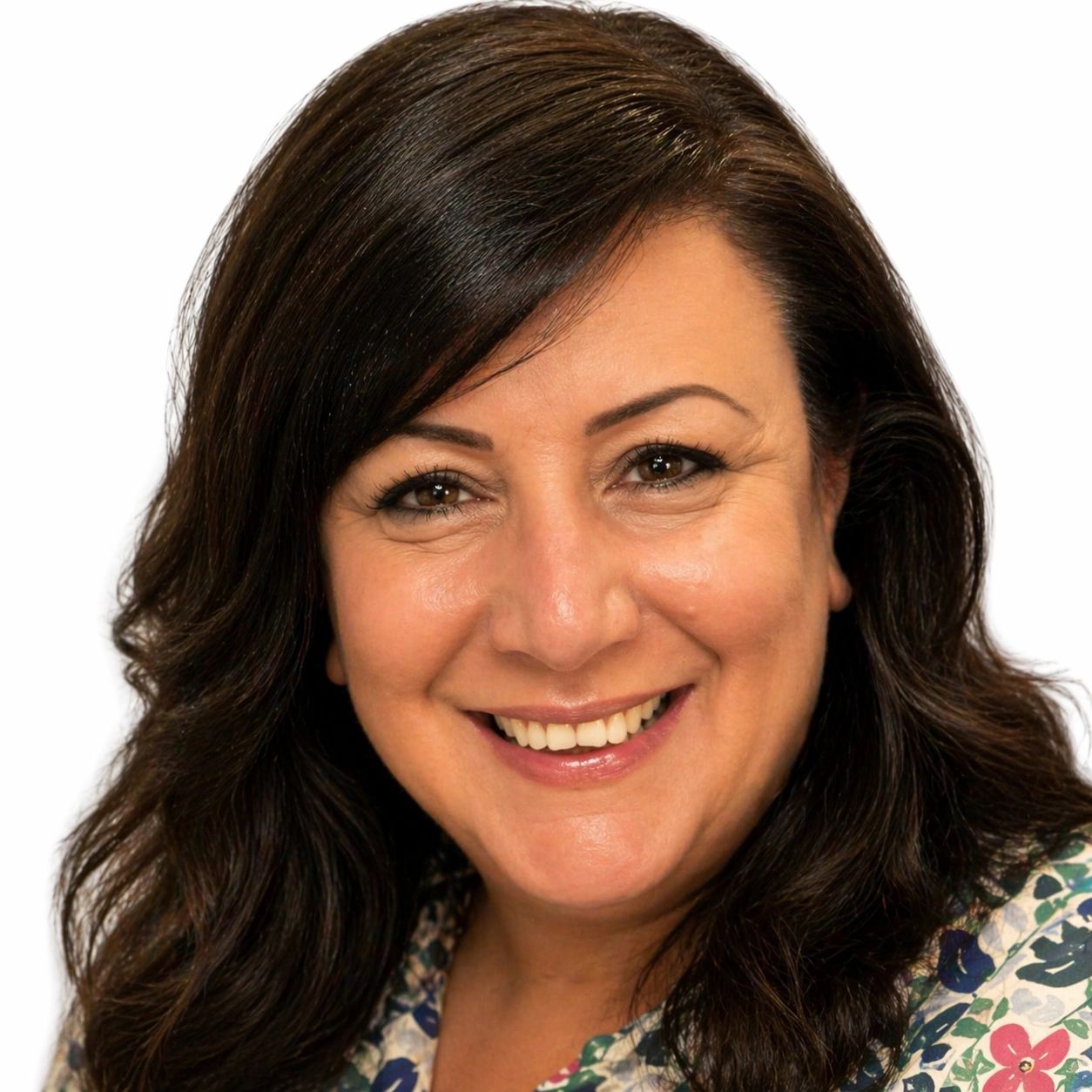 Smiling woman with dark hair and floral blouse against a white background.
