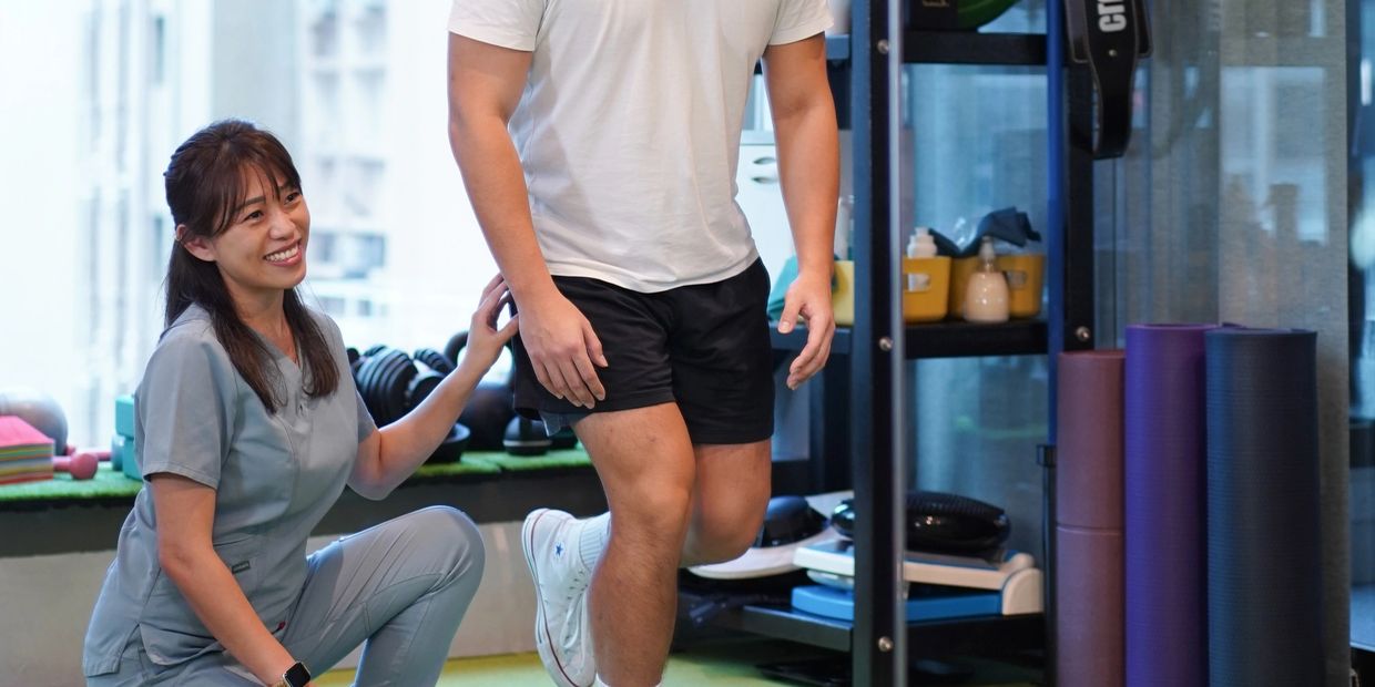 理疗师指导男性患者做膝关节康复训练。