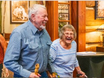 Elderly couple laughing joyfully indoors.
