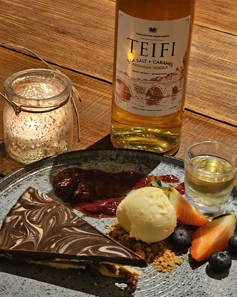 A chocolate tiffin dessert with berries and icecream, with the sea salt and caramel vodka 