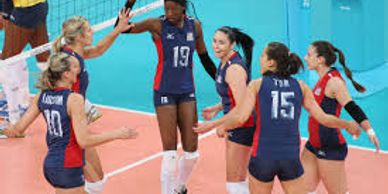 Volleyball players celebrating on court after a point.