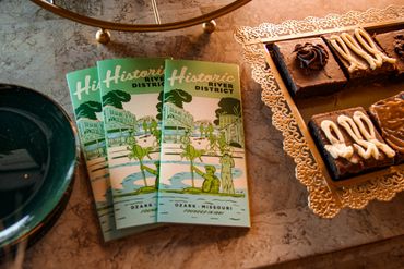 Historic River District brochures next to chocolate brownies on a table.