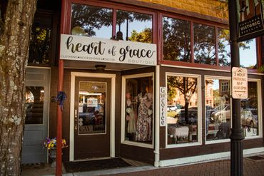 Front view of Heart of Grace Boutique with clothing displays.