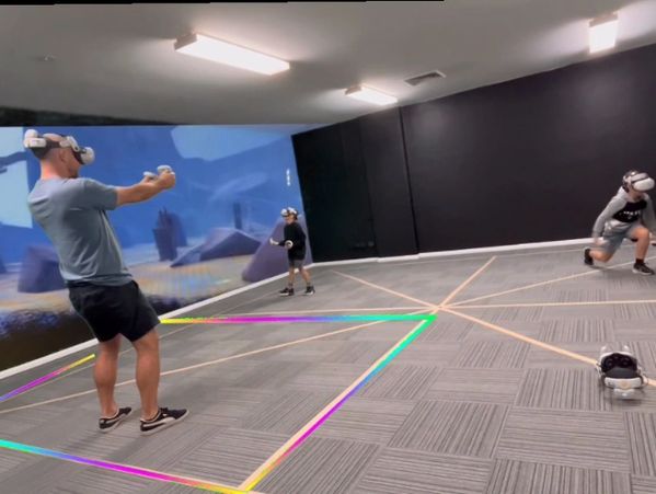 People playing baseball in an indoor virtual reality setup.