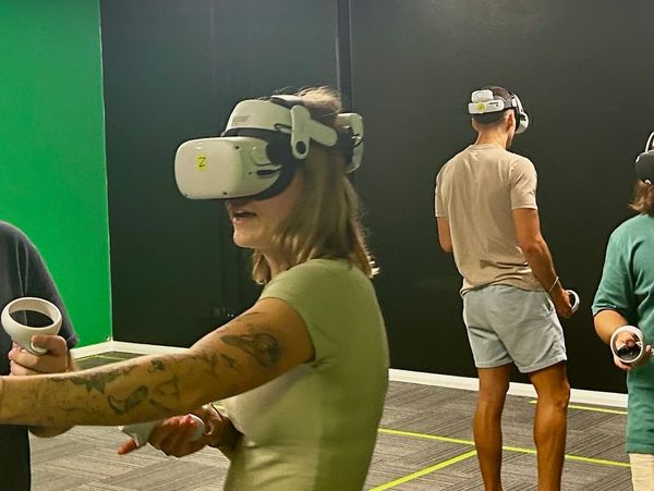 People enjoying a virtual reality gaming session with VR headsets and controllers.