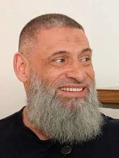 Smiling man with a full gray beard and short hair.