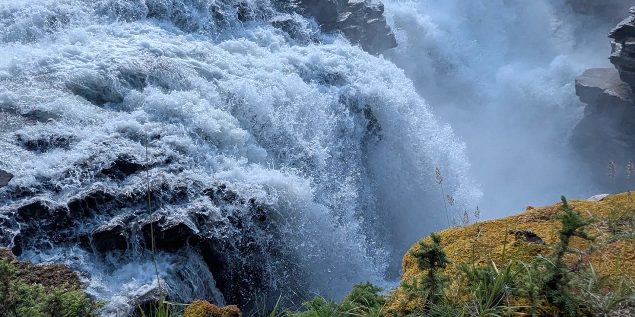 Powerful waterfall with mist and rocks.