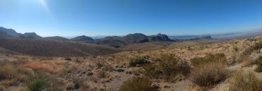 Desert landscape with mountains under clear blue sky.