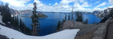 Snowy landscape overlooking a deep blue lake.