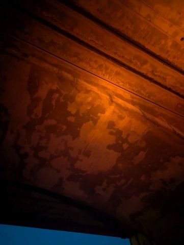 Orange paint on a ceiling with pipe lines.