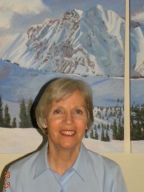 Pam Traver in front of her oil painting triptych of Alta, Utah,  She has skied at Alta for several y