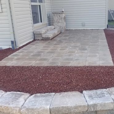 Retaining wall surrounding a functional paver patio