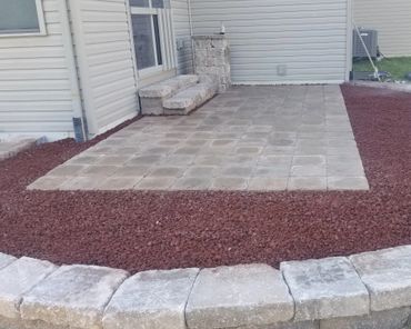Retaining wall surrounding a functional paver patio