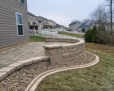 Retaining wall surrounding a functional paver patio