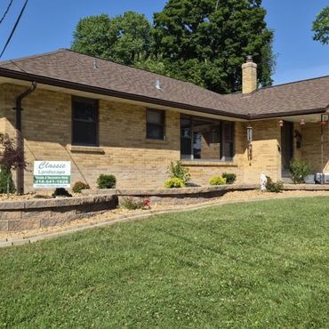 Well-maintained brick house with landscaped front yard.