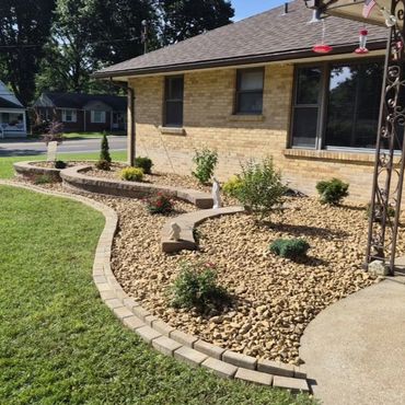 Neatly landscaped front yard with stones and small plants.