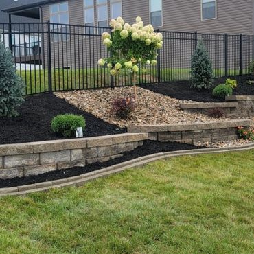 Landscaped garden with stone retaining walls and plants.