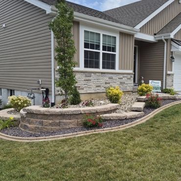 Modern house with landscaped front yard and stone wall.