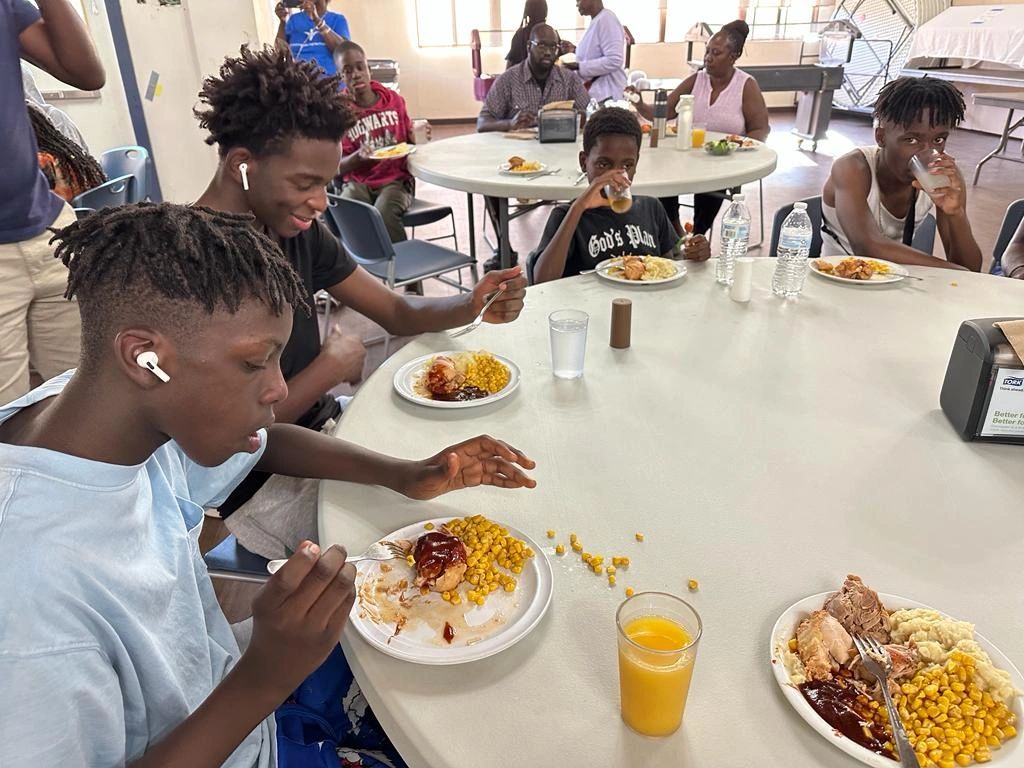 Youth sitting at a table having a meal